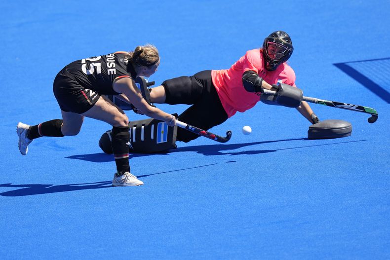 La arquera de Argentina, Cristina Cosentino, detiene el remate de Viktoria Huse, de Alemania, en la definición por penales de los cuartos de final del hockey sobte césped de los Juegos Olímpicos en el estadio Yves-du-Manoir el lunes 5 de agosto de 2024, en Colombes, Francia. (AP Foto/Aijaz Rahi)
