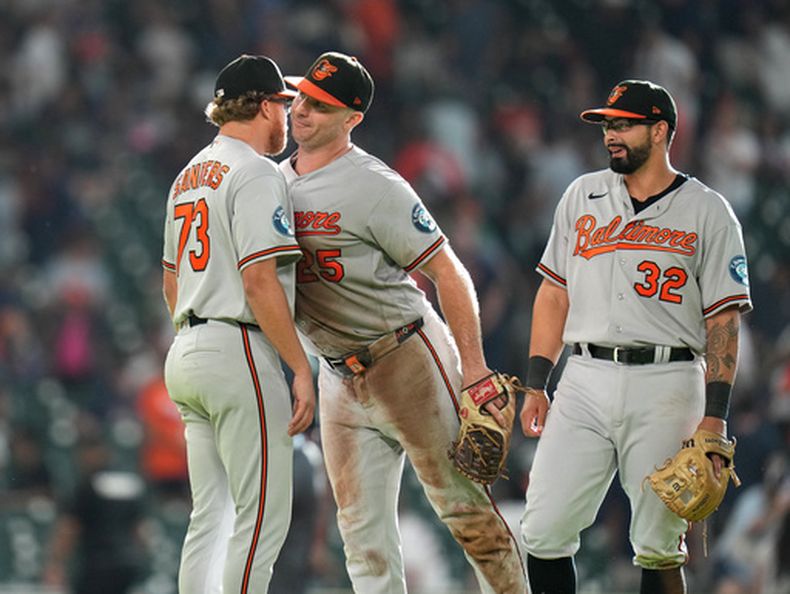 El lanzador relevista de los Orioles de Baltimore, Cam Sanders (izquierda), celebra con Pete Alonso (centro) y Christian Encarnacion-Strand (derecha) después de un partido de béisbol contra los Astros de Houston, el sábado 18 de julio de 2026, en Houston. (Foto AP/Karen Warren)