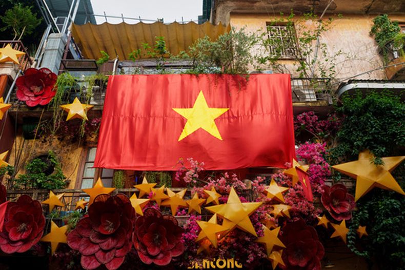 ARCHIVO - Una enorme bandera nacional de Vietnam cuelga de un balcón en el casco antiguo de Hanói, Vietnam, el lunes 1 de septiembre de 2025. (Foto AP/Vincent Thian, archivo)