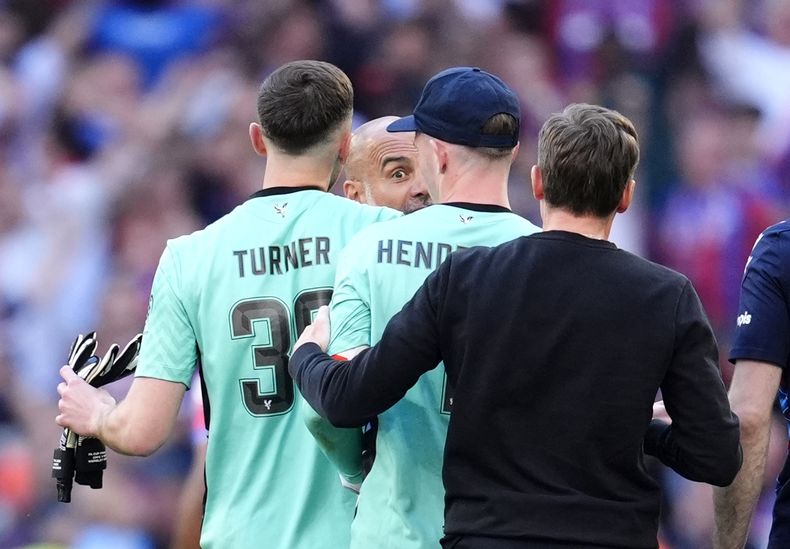 El entrenador del Manchester City, Pep Guardiola, se dirige al portero del Crystal Palace, Dean Henderson, mientras su compañero de equipo Matt Turner interviene después de la final de la Copa FA entre el Manchester City y el Crystal Palace en el estadio de Wembley en Londres, el sábado 17 de mayo de 2025. (Nick Potts/PA vía AP)