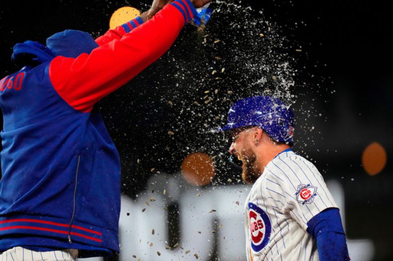 Michael Busch, de los Cachorros de Chicago, festeja mientras sus compañeros le arrojan agua y semillas de girasol, luego de gestionar el boleto que significó el triunfo sobre los Rojos de Cincinnati, el miércoles 6 de mayo de 2026 (AP Foto/Erin Hooley)