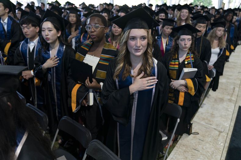 ARCHIVO - Estudiantes entonan el himno nacional de Estados Unidos durante una ceremonia de graduación de la generación Georgetown de 2022 en la Walsh School of Foreign Service, el sábado 21 de mayo de 2022, en Washington. (AP Foto/José Luis Magaña, archivo)