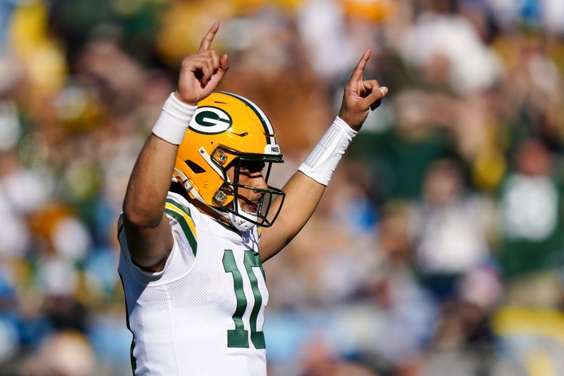 El quarterback de los Packers de Green Bay, Jordan Love celebra luego de una anotación del running back AJ Dillon durante la primera mitad del juego de la NFL ante los Panthers de Carolina, el domingo 24 de diciembre de 2023, en Charlotte, Carolina del Norte. (AP Foto/Jacob Kupferman)