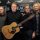 ARCHIVO - Los miembros de Eagles, de izquierda a derecha, Timothy B. Schmit, Don Henley, Glenn Frey y Joe Walsh posan con una guitarra autografiada después de una conferencia de prensa en el Festival de Cine de Sundance, el 19 de enero de 2013, en Park City, Utah. El miércoles 21 de febrero de 2024 inició un juicio penal inusual por la letra escrita a mano del éxito de rock de la banda, Hotel California. (Foto Chris Pizzello/Invision/AP, archivo)