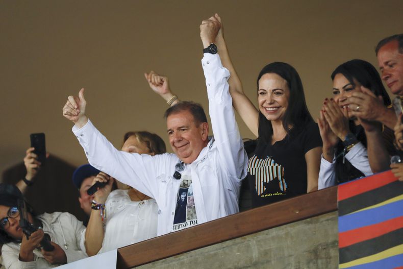 El candidato presidencial de la oposición venezolana Edmundo González, izquierda, y la líder opositora María Corina Machado levantan los brazos durante una reunión con jóvenes en la Universidad Central de Venezuela (UCV) en Caracas, Venezuela, el domingo 14 de julio de 2024. (AP Foto/Cristian Hernández )