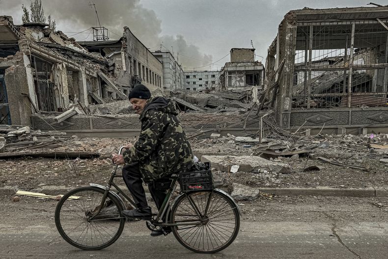 Un hombre circula en bicicleta frente a la oficina de correos destruida por un ataque aéreo ruso en Kurájove, en la región ucraniana de Donetsk, el 7 de noviembre de 2024. (AP Foto/Anton Shtuka)