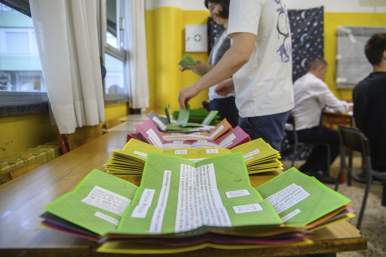 Papeletas de un referéndum sobre ciudadanía y protecciones laborales son preparadas en una mesa de un centro de votación en Milán, Italia, el domingo 8 de junio de 2025. (Claudio Furlan/LaPresse via AP)