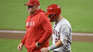 Mike Trout (27), de los Angelinos de Los Ángeles, camina al lado del manager Phil Nevin mientras abandona el partido contra de los Padres de San Diego, el lunes 3 de julio de 2023, en San Diego. (AP Foto/Denis Poroy)