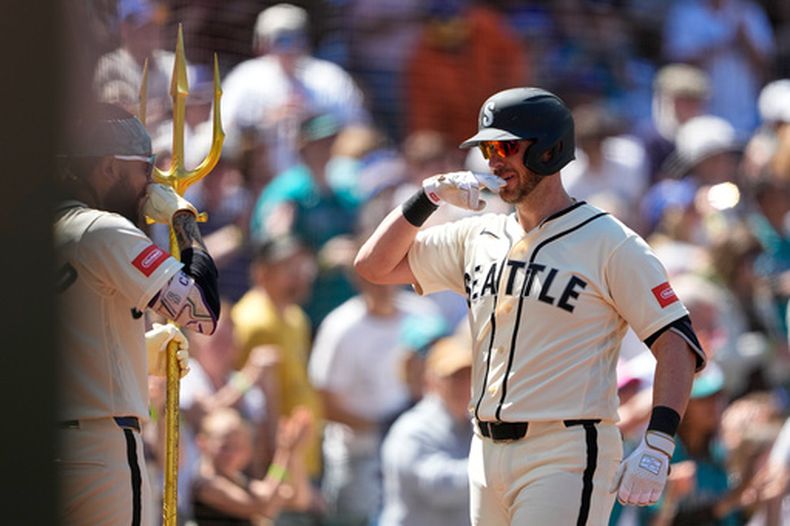 Mitch Garver, derecha, de los Marineros de Seattle, celebra con J.P. Crawford, izquierda, después de batear un jonrón de dos carreras contra los Azulejos de Toronto durante la cuarta entrada del juego de béisbol de Grandes Ligas, el domingo 5 de julio de 2026, en Seattle. (AP Foto/Lindsey Wasson)