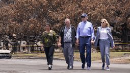 ARCHIVO - El presidente Joe Biden y la primera dama Jill Biden caminan con el gobernador de Hawai Josh Green, segundo por la izquierda, y su esposa Jaime Green mientras pasan por el enorme árbol Banyan durante su visita a las zonas devastadas por los incendios forestales de Maui, el 21 de agosto de 2023, en Lahaina, Hawai. (AP Foto/Evan Vucci, Archivo)