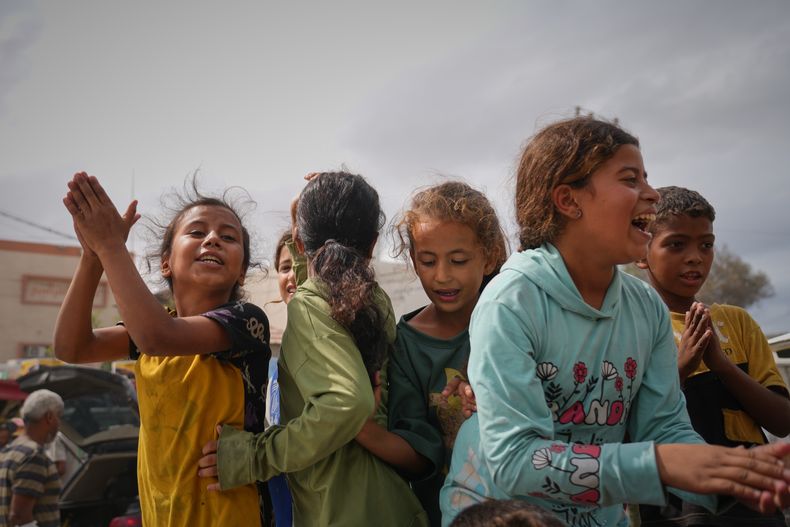 Niños palestinos celebran tras el anuncio de que Israel y Hamás han acordado la primera fase de un plan de paz para detener los combates, el jueves 9 de octubre de 2025, en Jan Yunis, en el sur de la Franja de Gaza. (AP Foto/Jehad Alshrafi)