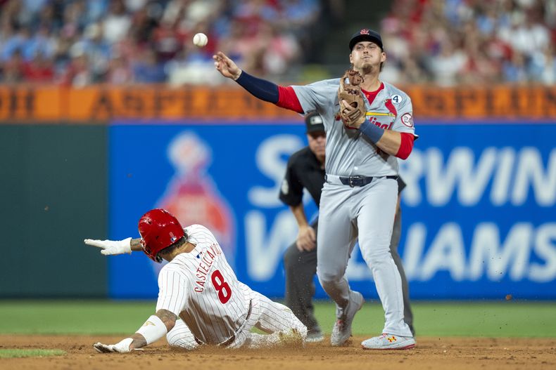 Nolan Gorman, derecha, segunda base de los Cardenales de San Luis, pone out a Nick Castellanos (8), de los Filis de Filadeflia, durante la sexta entrada del juego de béisbol del domingo 2 de junio de 2024, en Filadelfia. (AP Foto/Chris Szagola)