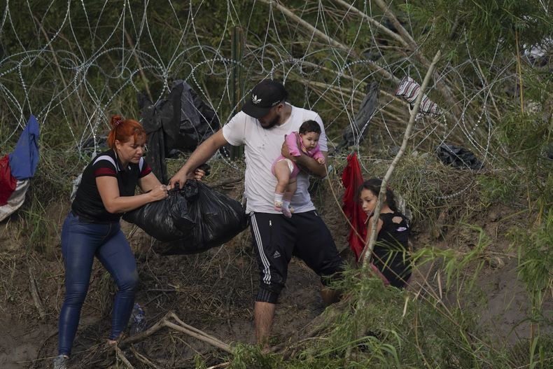 Una familia de migrantes camina por la orilla del río Bravo (Rio Grande, en inglés) del lado estadounidense, en una imagen tomada el miércoles 10 de mayo de 2023 desde Matamoros, México. Solicitantes de asilo han llegado en grandes números a la frontera entre Estados Unidos y México en anticipación a la suspensión de la restricción al asilo conocida como Título 42, la cual le había permitido al gobierno estadounidense expulsar rápidamente a los migrantes hacia México. El miércoles se anunciaron nuevas medidas que establecen nuevas vías legales para los migrantes. (AP Foto/Fernando Llano)