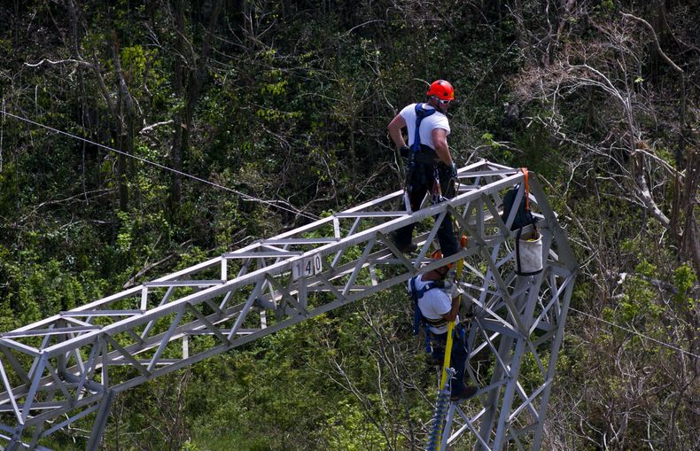 Trabajadores intentan restaurar el tendido eléctrico dañado por el paso del huracán María, el 15 de octubre de 2017, en Barceloneta, Puerto Rico. (AP Foto/Ramón Espinosa, archivo)