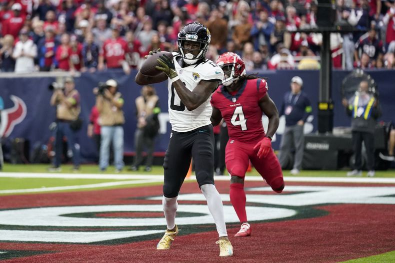 El wide receiver Calvin Ridley (0), de los Jaguars de Jacksonville, atrapa un pase de anotación frente al cornerback Tavierre Thomas (4), de los Texans de Houston, en la segunda mitad del juego de la NFL del domingo 26 de noviembre de 2023, en Houston. (AP Foto/Eric Gay)