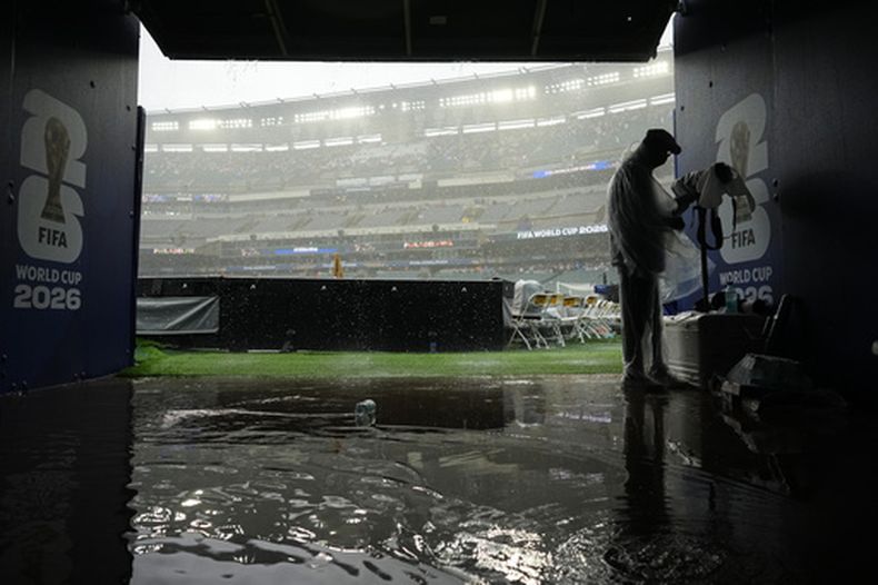 Un fotógrafo se guarece de la lluvia que obligó a suspender el partido mundialista entre Francia e Irak el lunes 22 de junio de 2026 (AP Foto/Petr David Josek)