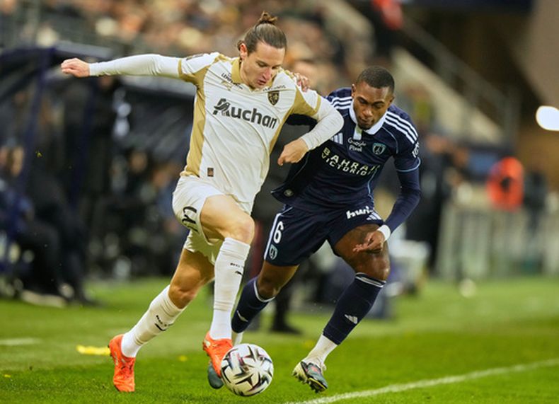 Florian Thauvin, a la izquierda, del Lens, dribla ante Otávio (Otávio Ataíde da Silva), del París FC, durante el juego de fútbol de la Ligue 1 francesa entre el París FC y el Lens en París, el sábado 14 de febrero de 2026. (Foto AP/Michel Euler)
