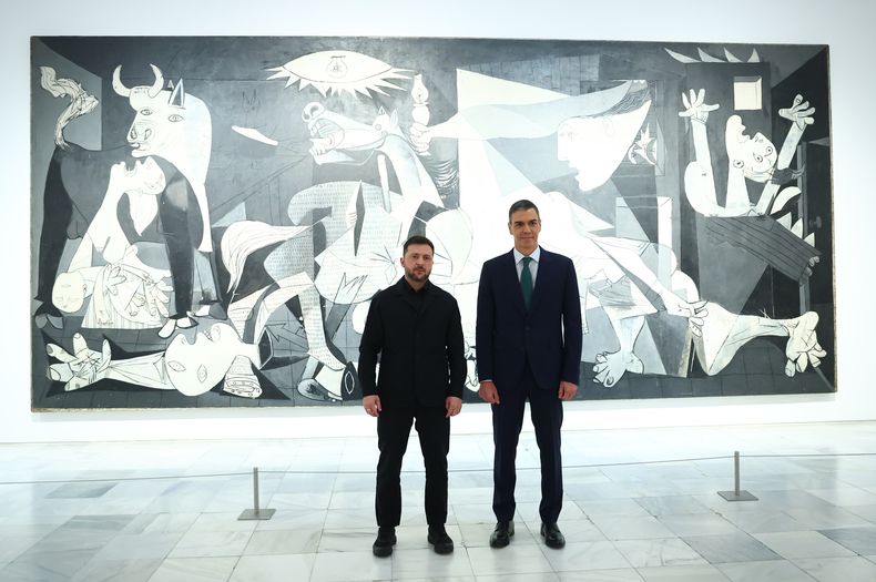 En la imagen, proporcionada por el gobierno español, el presidente ucraniano Volodymyr Zelenskyy posa con el presidente del gobierno de España, Pedro Sánchez, frente a “Guernica” de Pablo Picasso, en Madrid, el martes 18 de noviembre de 2025. (Gobierno de España vía AP)