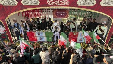 Un grupo de personas despiden los féretros, envueltos en banderas iraníes, de los científicos nucleares fallecidos en ataques israelíes, durante su funeral en Teherán. Irán, el 28 de junio de 2025. (AP Foto/Vahid Salemi)