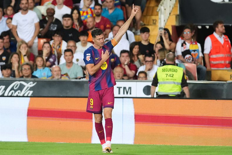 Robert Lewandowski, del Barcelona, celebra tras anotar el primer gol de su equipo durante el partido de fútbol de la Liga española entre el Valencia y el FC Barcelona en Valencia, España, el sábado 23 de mayo de 2026. (Foto AP/Alberto Saiz)