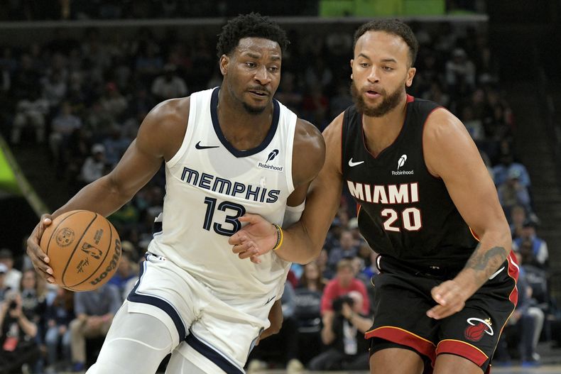 El alero de los Grizzlies de Memphis, Jaren Jackson Jr. (13), maneja el balón contra el alero del Heat de Miami Kyle Anderson (20) en la primera mitad de un partido de baloncesto de la NBA, el sábado 15 de marzo de 2025, en Memphis, Tennessee. (AP Foto/Brandon Dill)