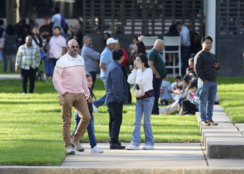 Una mujer se cubre la cara mientras espera con otras personas afuera de la Iglesia Lakewood, el domingo 11 de febrero de 2024, en Houston, después de un tiroteo reportado durante un servicio religioso en español. (Karen Warren/Houston Chronicle vía AP)