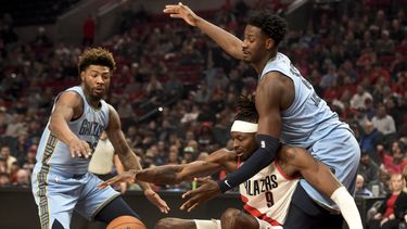Jerami Grant, centro, de los Trail Blazers de Portland, y Jaren Jackson Jr., derecha, de los Grizzlies de Memphis, disputan un balón mientras Marcus Smart, izquierda, se acerca para pelearlo, durante la primera mitad del juego de baloncesto de la NBA, en Portland, Oregon, el domingo 5 de noviembre de 2023. (AP Foto/Steve Dykes)