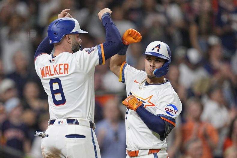 Ramón Urías, derecha, de los Astros de Houston, celebra con Christian Walker (8) después de batear un cuadrangular de dos carreras frente a los Medias Rojas de Boston durante la quinta entrada del juego de béisbol de Grandes Ligas el lunes 11 de agosto de 2025, en Houston. (AP Foto/David J. Phillip)