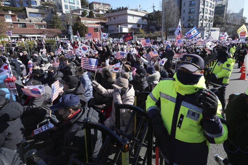 Partidarios del destituido presidente surcoreano Yoon Suk Yeol celebran una marcha tras noticias de que una corte había emitido una orden de detención contra Yoon, cerca de su residencia oficial en Seúl, Corea del Sur, el martes 31 de diciembre de 2024. (AP Foto/Lee Jin-man)