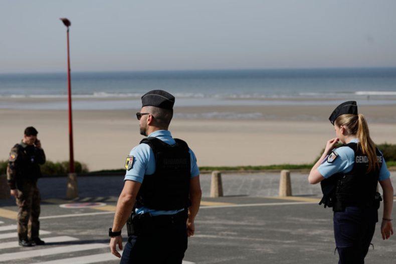Policías montan guardia tras un incidente entre un taxi acuático con migrantes, en Equihen-Plage, al norte de Francia, el jueves 9 de abril de 2026. (Foto AP/Jean-Francois Badias)