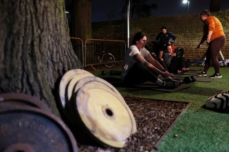 ARCHIVO - Chloe Spriggs, a la izquierda, descansa un poco durante un entrenamiento con pesas de las integrantes del equipo femenino de rugby de Teddington, el jueves 16 de enero de 2025, en la casa club en Bushy Park, Londres. (AP Foto/Charlotte Coney, archivo)
