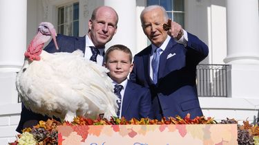 El presidente Joe Biden, derecha, señala a lo lejos junto a John Zimmerman, izquierda, presidente de la Federación Nacional de Pavos; su hijo Grant Zimmerman, al centro, y el pavo nacional del Día de Acción de Gracias, de nombre Peach, durante una ceremonia de indulto en la Casa Blanca, el lunes 25 de noviembre de 2024, en Washington. (AP Foto/Susan Walsh)
