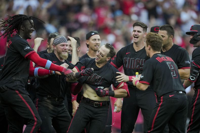 Spencer Steer de loe Rojos de Cincinnati celebra con sus compañeros tras conectar el jonrón de dos carreras en la 11ma entrada para la victoria ante los Padres de San Diego el viernes 30 de junio del 2023. (AP Foto/Aaron Doster)