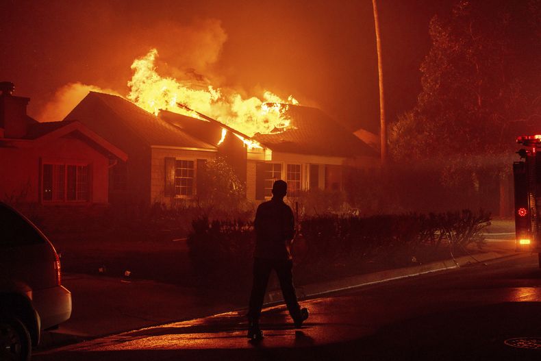 En esta imagen de archivo, un bombero camina hacia una estructura en llamas mientras el incendio de Eaton avanza, el 7 de enero de 2025, en Altadena, California. (AP Foto/Ethan Swope, archivo)
