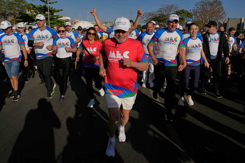 ARCHIVO - El presidente de Brasil, Luiz Inácio Lula da Silva, al centro, y la primera dama Rosángela da Silva, a la izquierda con camiseta roja, participan en una caminata para conmemorar el 95º aniversario del Ministerio de Cultura, en Brasilia, Brasil, el 28 de septiembre de 2025. (Foto AP/Eraldo Peres, Archivo)