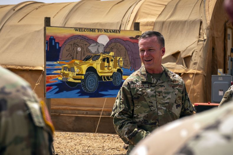 En esta imagen de la Fuerza Aérea de Estados Unidos, el general de división Kenneth P. Ekman habla delante de un cartel de Bienvenido a Niamey que muestra vehículos militares de Estados Unidos en la base aérea 101 en Níger, el 30 de mayo de 2024. (Sargento técnico Christopher Dyer, Fuerza Aérea de Estados Unidos vía AP)