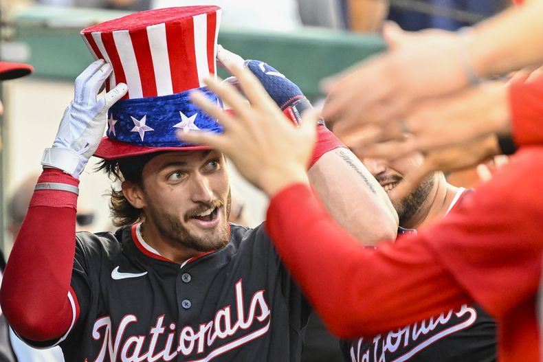 Dylan Crews, de los Nacionales de Washington, es recibido en el dugout por sus compañeros de equipo después de conectar su primer jonrón en las Grandes Ligas durante la primera entrada contra los Yankees de Nueva York, el miércoles 28 de agosto de 2024, en Washington. (AP Foto/John McDonnell)