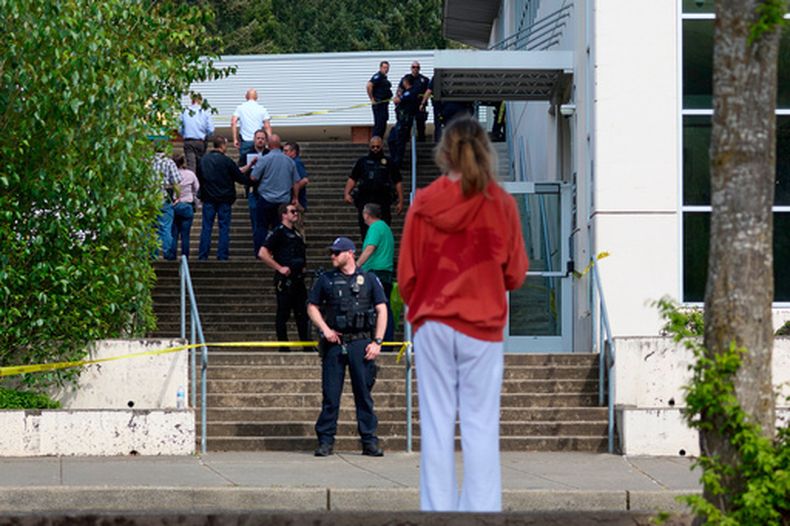 Un estudiante observa a agentes de la Policía de Tacoma luego de que varias personas resultaron heridas en un apuñalamiento masivo en la Escuela Secundaria Foss, el jueves 30 de abril de 2026, en Tacoma, Washington. (AP Foto/John Froschauer)