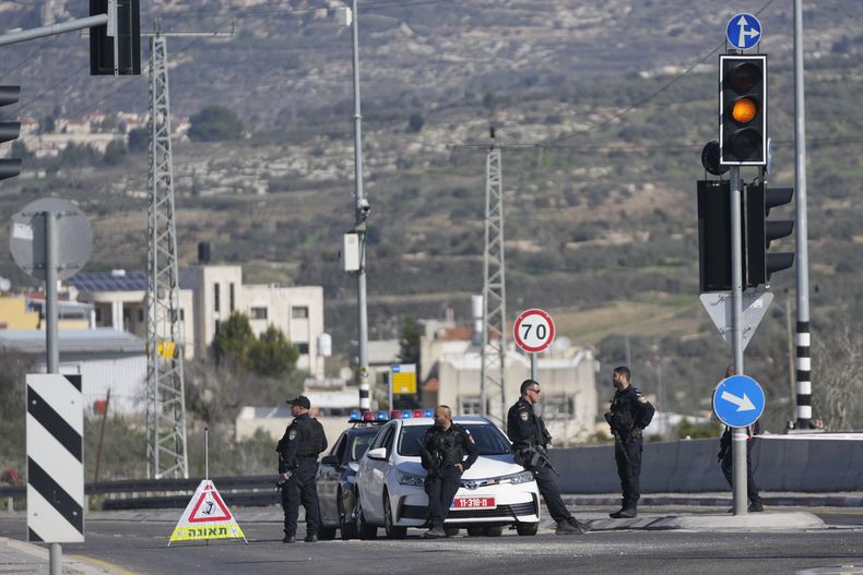 Policías israelíes bloquean una carretera principal después de que hombres armados abrieran fuego contra coches y un autobús que transportaba israelíes en la Cisjordania ocupada, matando al menos a tres personas, cerca de la aldea palestina de Al-Funduq, el lunes 6 de enero de 2025. (AP foto/Nasser Nasser)