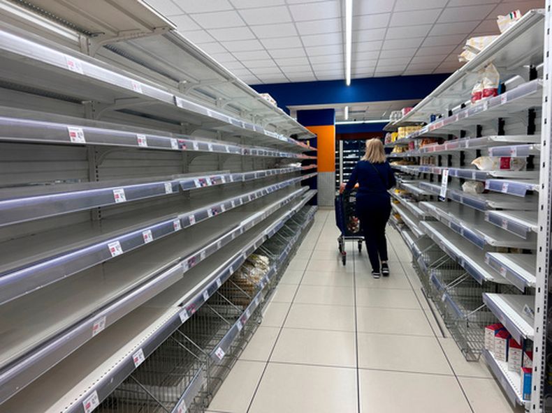Una mujer camina frente a estantes vacíos en Nápoles, Italia, el martes 20 de octubre de 2026. (AP Foto/Alessandra Tarantino)