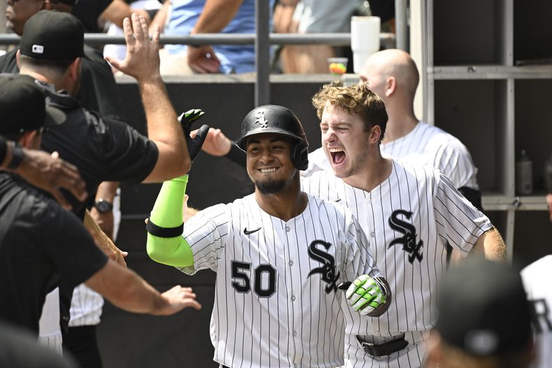 Lenyn Sosa (50), de los Medias Blancas de Chicago, celebra en el dugout con Kyle Teel, derecha, y sus demás compañeros de equipo después de batear un jonrón de dos carreras durante la primera entrada del juego de béisbol de Grandes Ligas frente a los Guardianes de Cleveland, el domingo 10 de agosto de 2025, en Chicago. (AP Foto/Matt Marton)