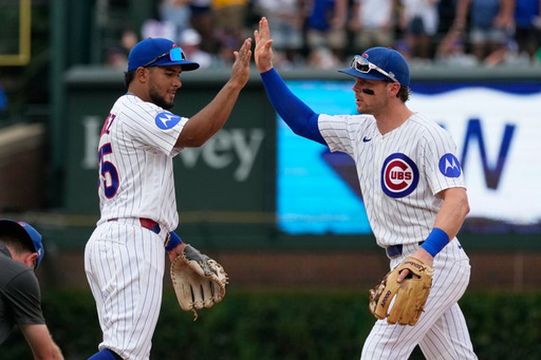 El segunda base Pedro Ramírez celebra con su compañero de los Cachorros de Chicago Nico Hoerner la victoria ante los Piratas de Pittsburgh el sábado 12 de septiembre del 2026. (AP Foto/Nam Y. Huh)