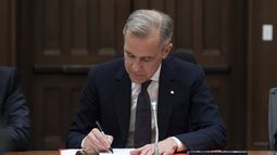 El primer ministro de Canadá, Mark Carney, firma un documento durante una reunión del gabinete en Parliament Hill, el viernes 14 de marzo de 2025 en Ottawa. (Adrian Wyld/The Canadian Press via AP)
