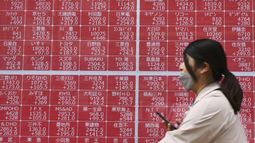 Una persona pasa por delante de una pantalla con cotizaciones en una empresa bursátil, en Tokio, el 10 de abril de 2025. (Kyodo News vía AP)