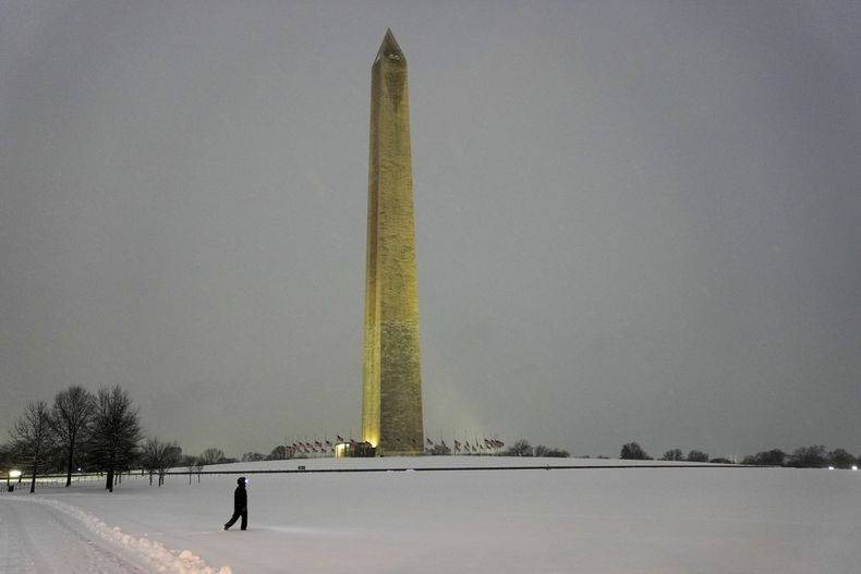Una persona camina cerca del Monumento a Washington durante una tormenta de nieve invernal en Washington, el lunes 6 de enero de 2025. (AP foto/Matt Rourke)