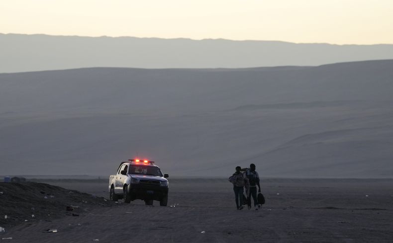Migrantes son escoltados por la policía peruana para regresar a la frontera con Chile, en Tacna, Perú, el viernes 28 de abril de 2023. (AP Foto/Martín Mejía)