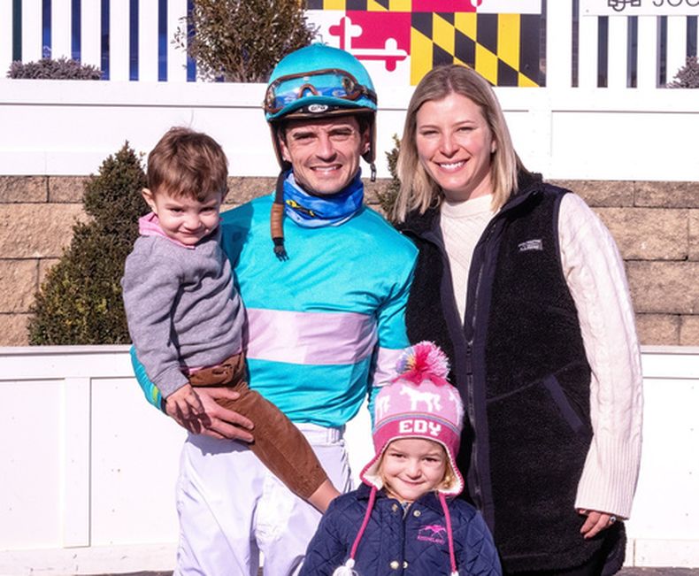En esta foto distribuida por The Maryland Jockey Club, el jockey Sheldon Russell y su esposa, la entrenadora Brittany, posan en el círculo de ganadores con sus hijos Rye y Edy el 31 de diciembre de 2023 en Laurel (Jim McCue/The Maryland Jockey Club via AP)