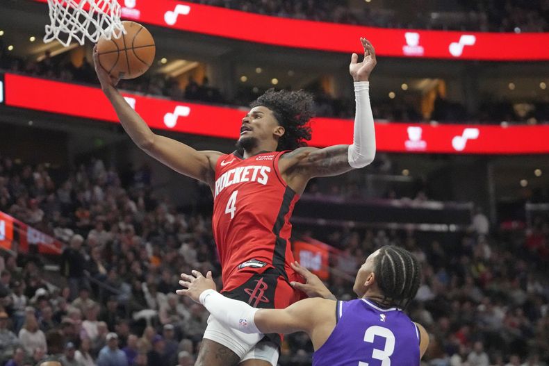 Jalen Green (4), de los Rockets de Houston, ataca la canasta ante la mirada de Keyonte George (3), del Jazz de Utah, durante la segunda mitad del juego de baloncesto de la NBA, el viernes 29 de marzo de 2024, en Salt Lake City. (AP Foto/Rick Bowmer)