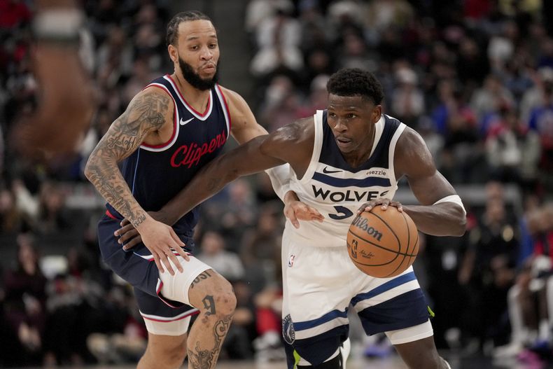 Anthony Edwards, de los Timberwolves de Minnesota, conduce el balón grente a Amir Coffey, de los Clippers de Los Ángeles, durante la segunda mitad del juego de baloncesto de la NBA, el miércoles 4 de diciembre de 2024, en Inglewood, California. (AP Foto/Eric Thayer)