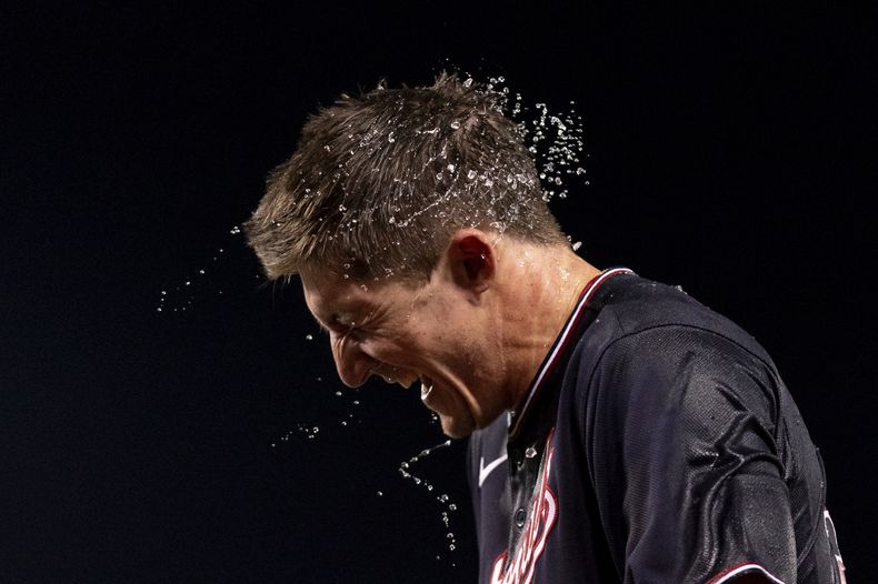 Jacob Young, de los Nacionales de Washington, ríe tras ser empapado por sus compañeros en la celebración de su sencillo decisivo en el duelo ante los Mets de Nueva York, el miércoles 6 de septiembre de 2023 (AP Foto/Stephanie Scarbrough)